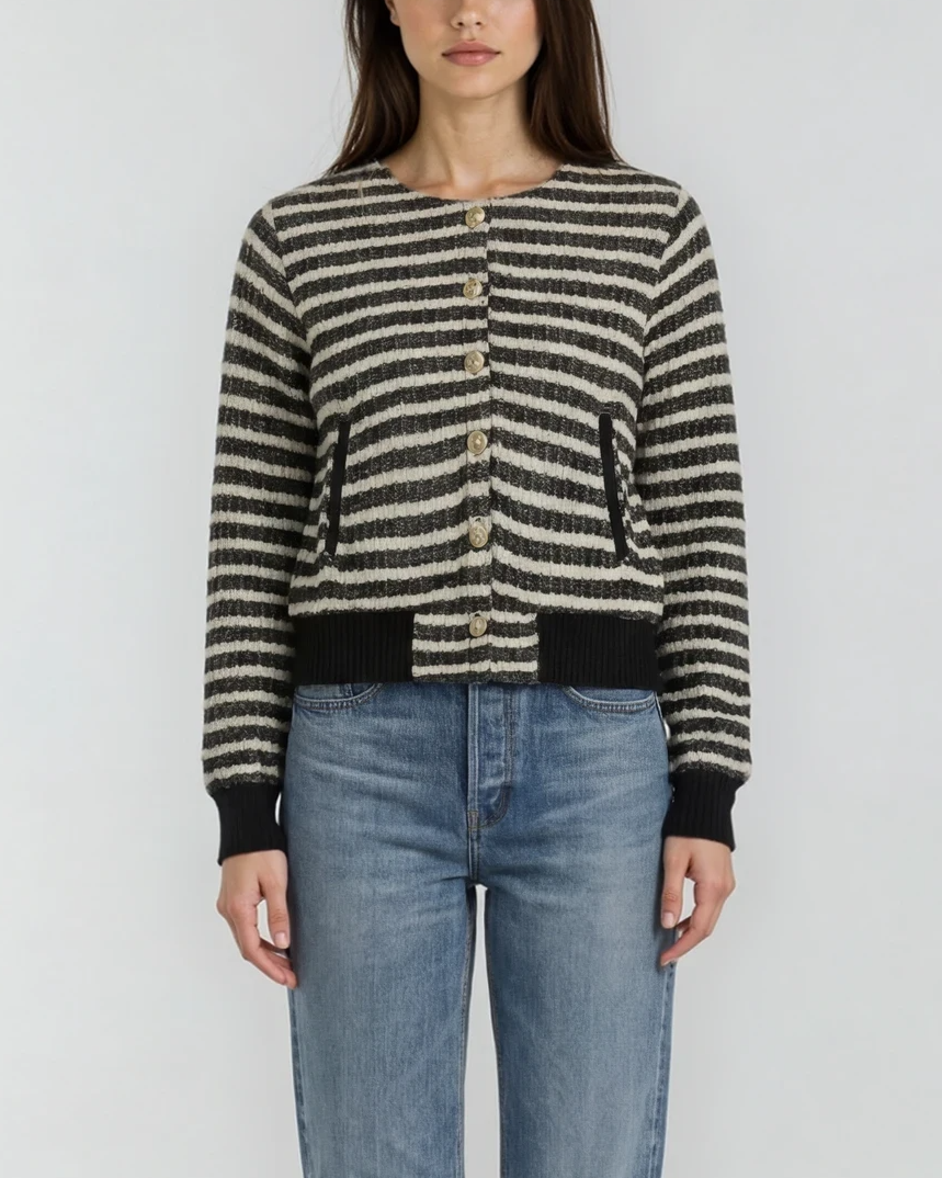 female model wearing a striped cardigan jacket with black cuffs and pockets and gold buttons on a white background