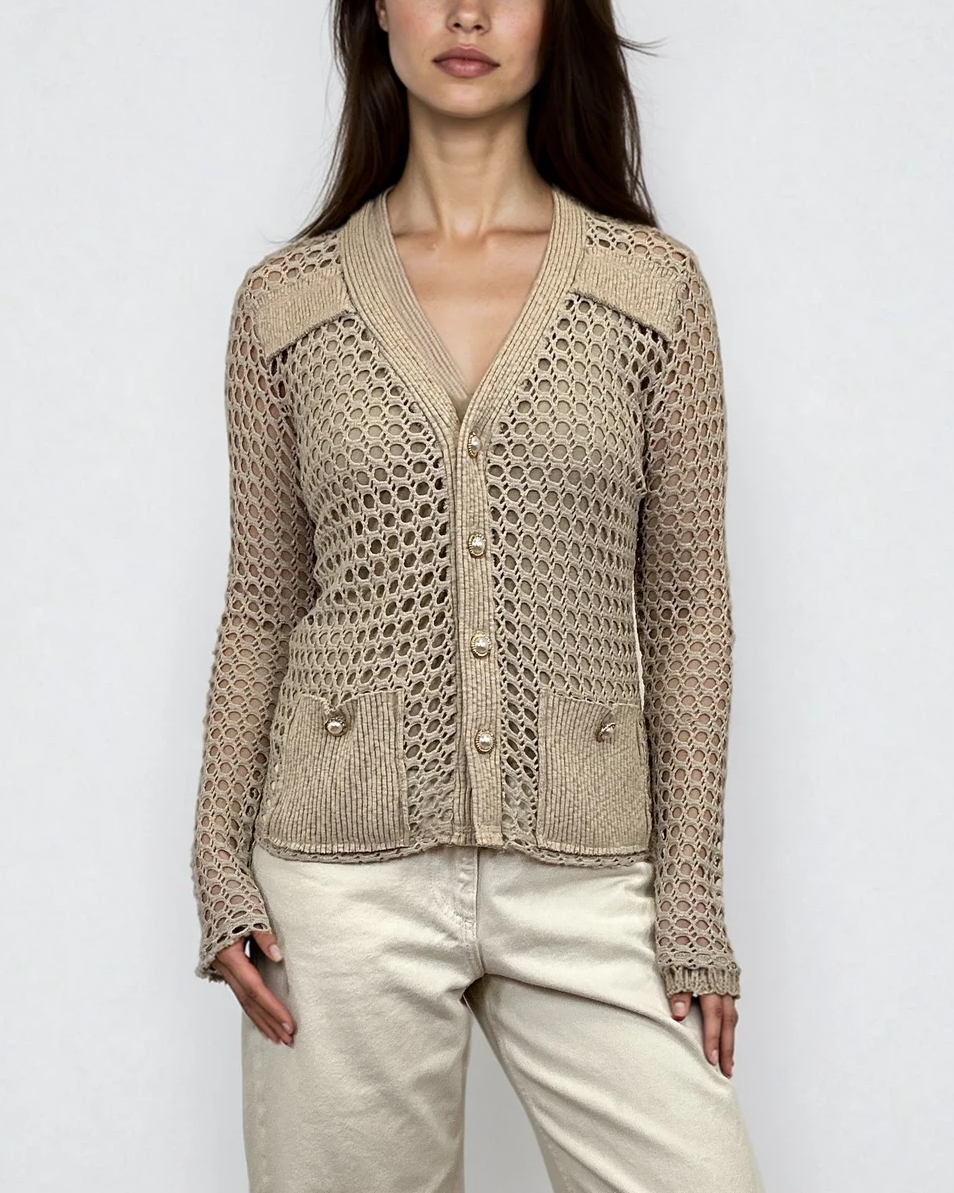 Female model wearing a crochet oatmeal lurex, beige shiny, metallic long sleeve cotton knit cardigan with a V-neckline and vintage gold pearl buttons and front pockets - Pete Collection