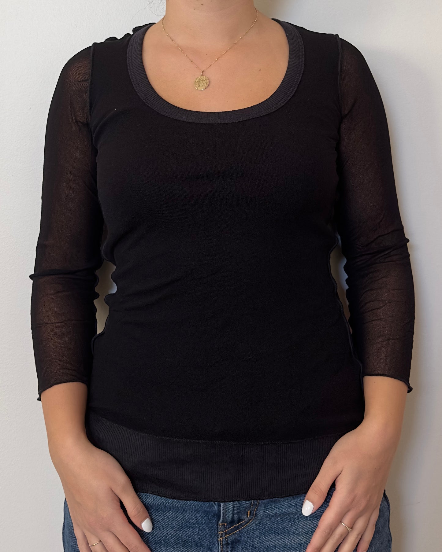 Female model wearing a cotton and mesh black long sleeve top with a ribbed front and mesh sleeves - Pete Collection