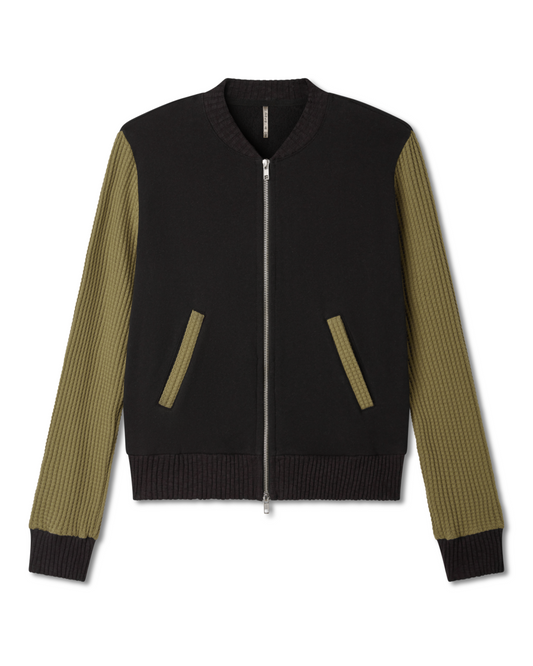 Female model wearing a black and green olive moss bomber jacket on a white background. Pete Collection
