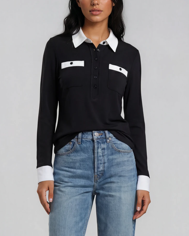 A model stands against a light gray studio background wearing a black long-sleeve polo shirt with a white collar and chest pocket trim, light blue straight-leg jeans, and black leather loafers. contrast collar polo - pete collection