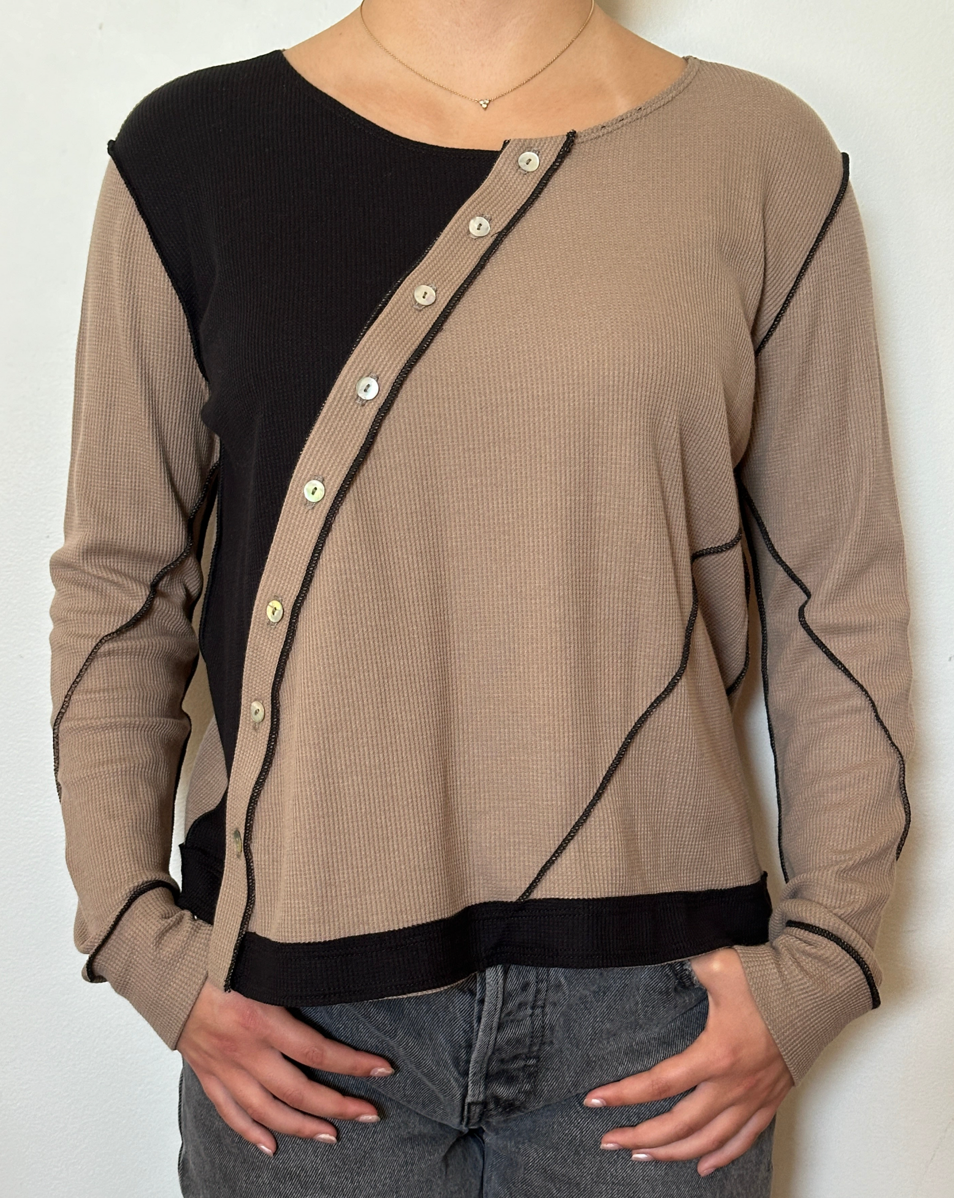 Female model wearing a black and bark (beige) asymmetrical long sleeve jersey - Pete Collection