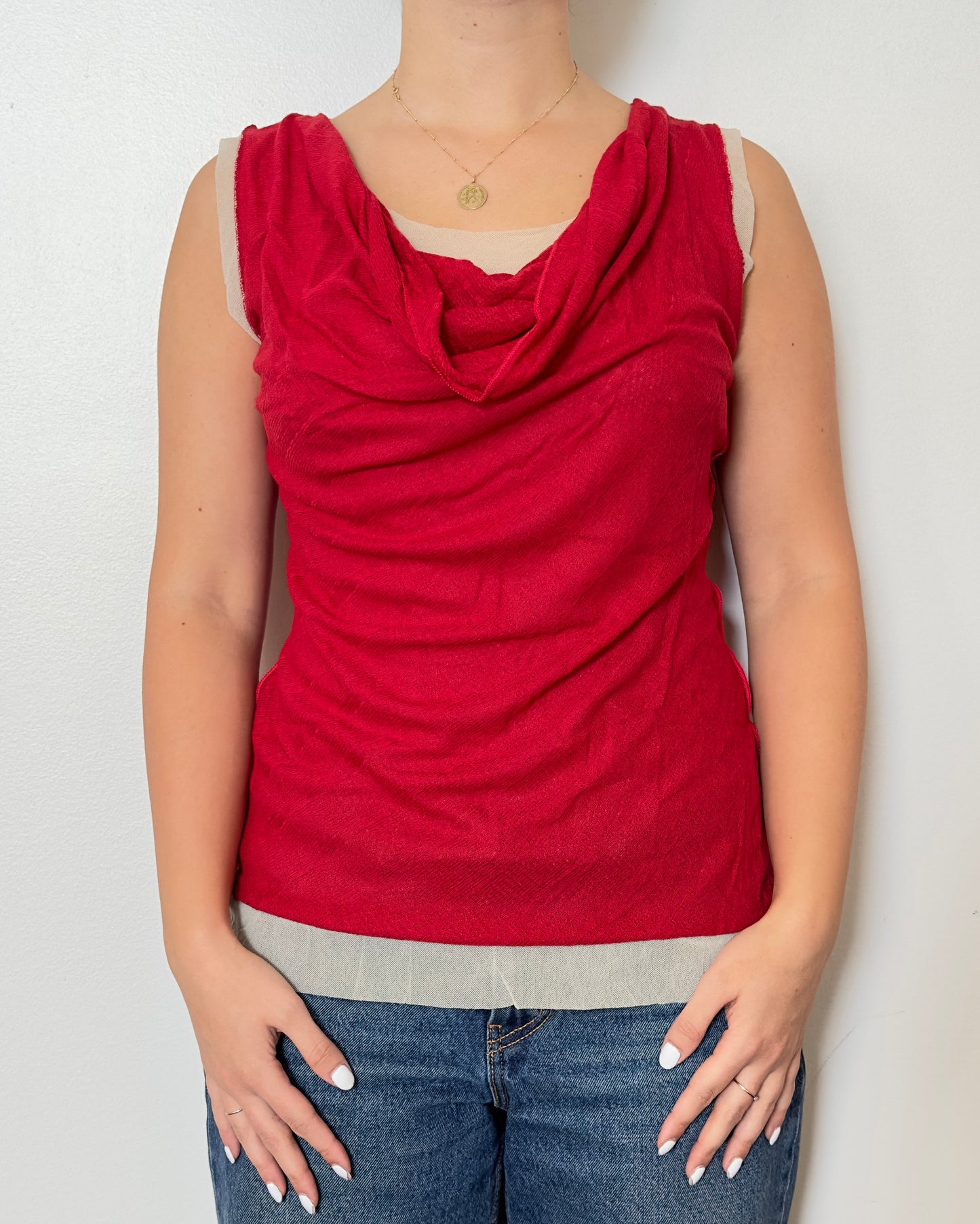 Female model wearing a ruffled pointelle tank top in a red color with a mesh tank under